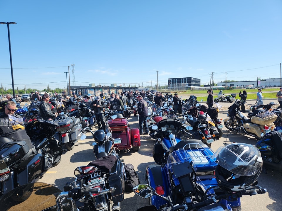 Large group of riders gathered in a parking lot at a chapter event