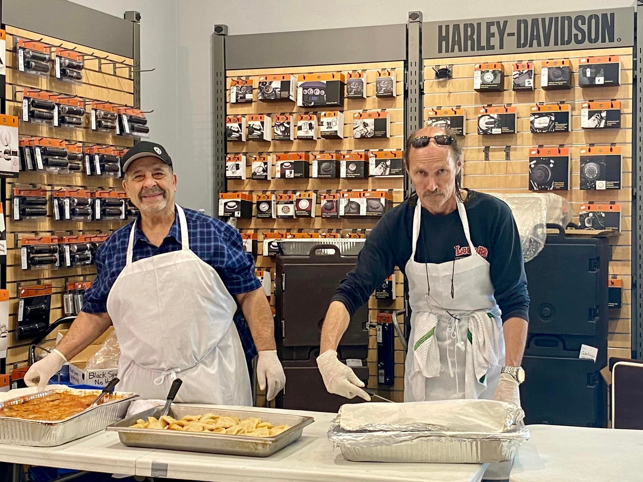 Two members serving food at the Harley-Davidson dealership event