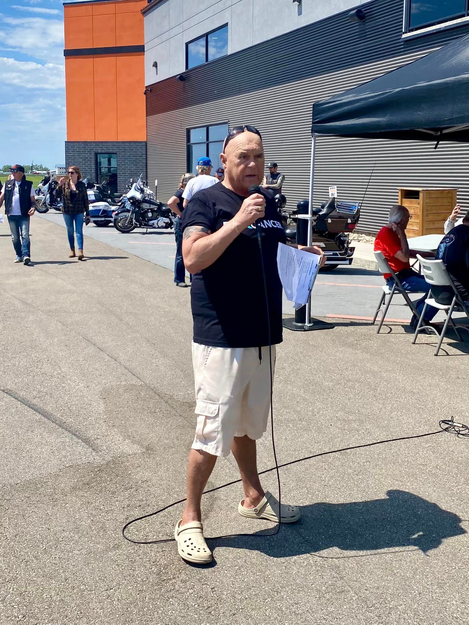 Member speaking at the mic outside Prairie Harley-Davidson