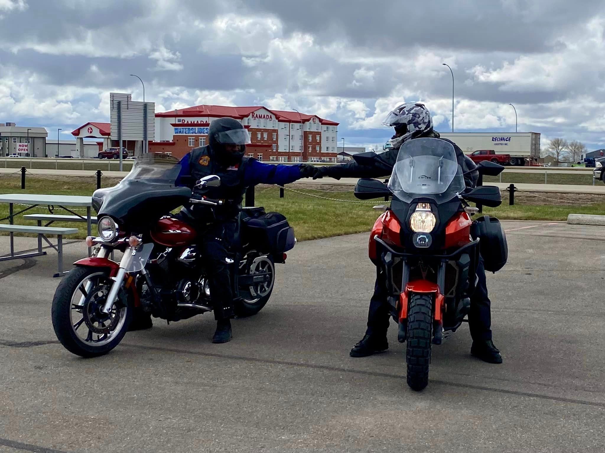 Regina HOG Chapter 9252 two riders fist bump at a ride stop