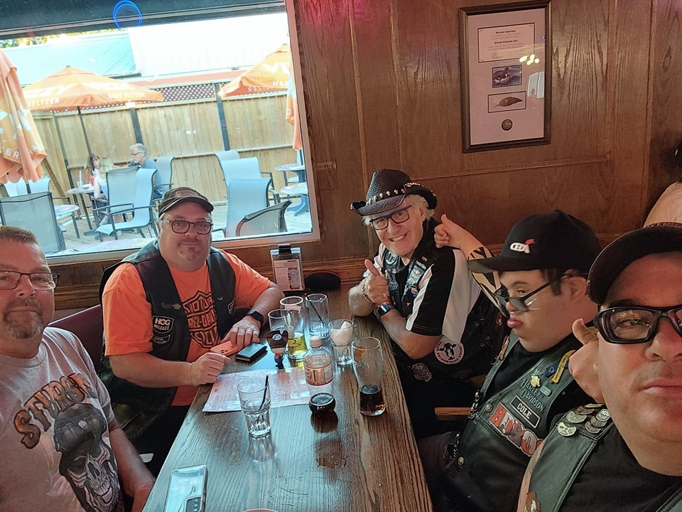 Chapter members gathered around a table at a bar on a ride stop