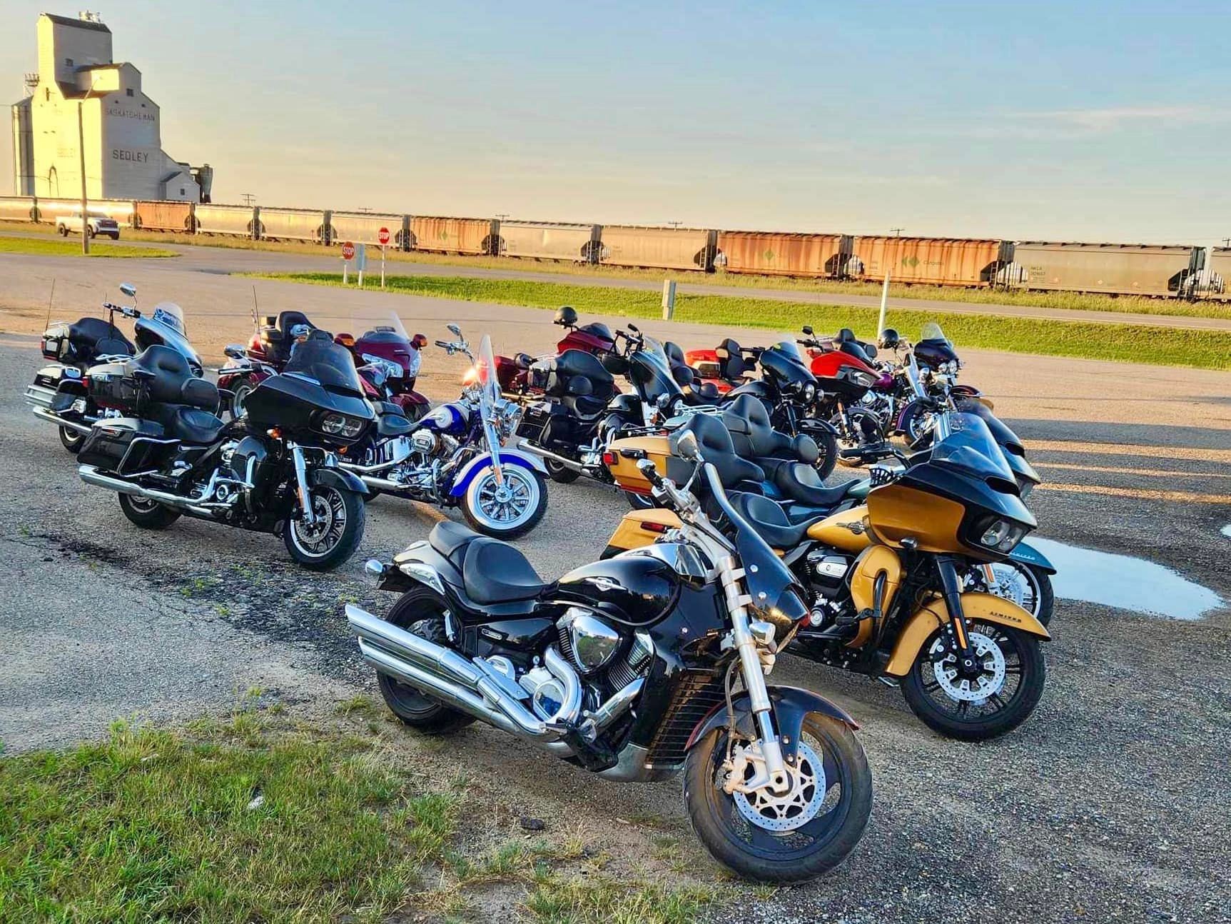 Large group of bikes parked in Sedley with the Saskatchewan grain elevator in the background