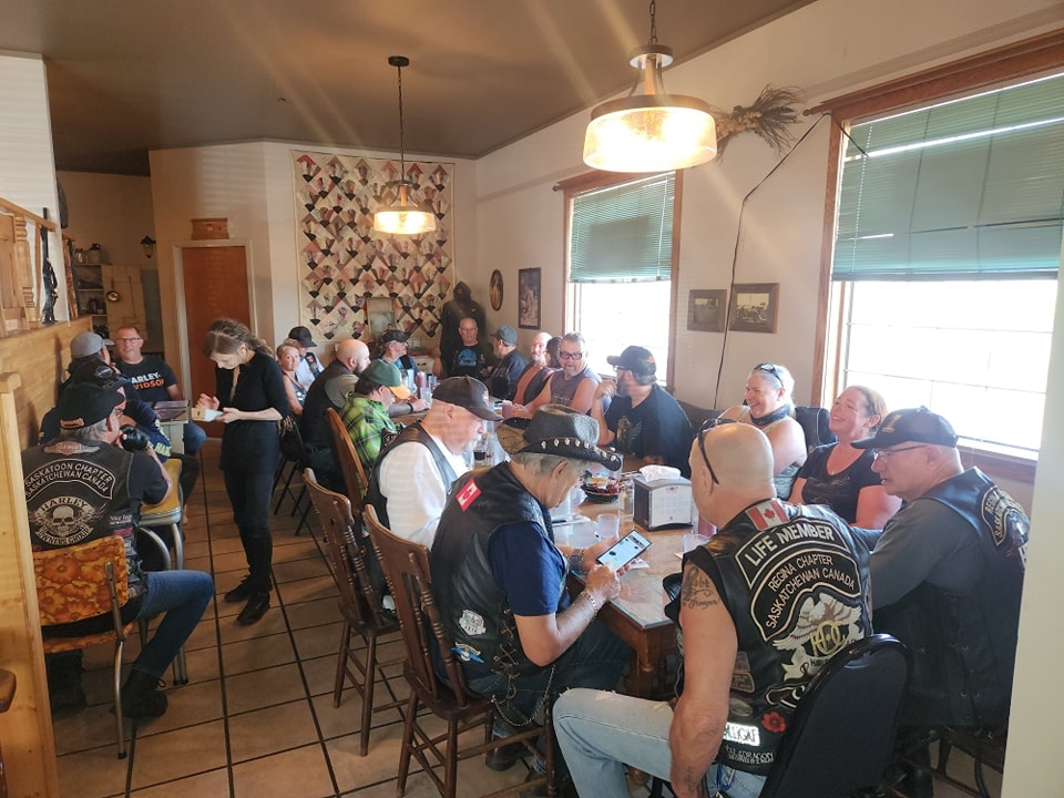 Chapter members filling a farmhouse dining room for a group meal on a ride