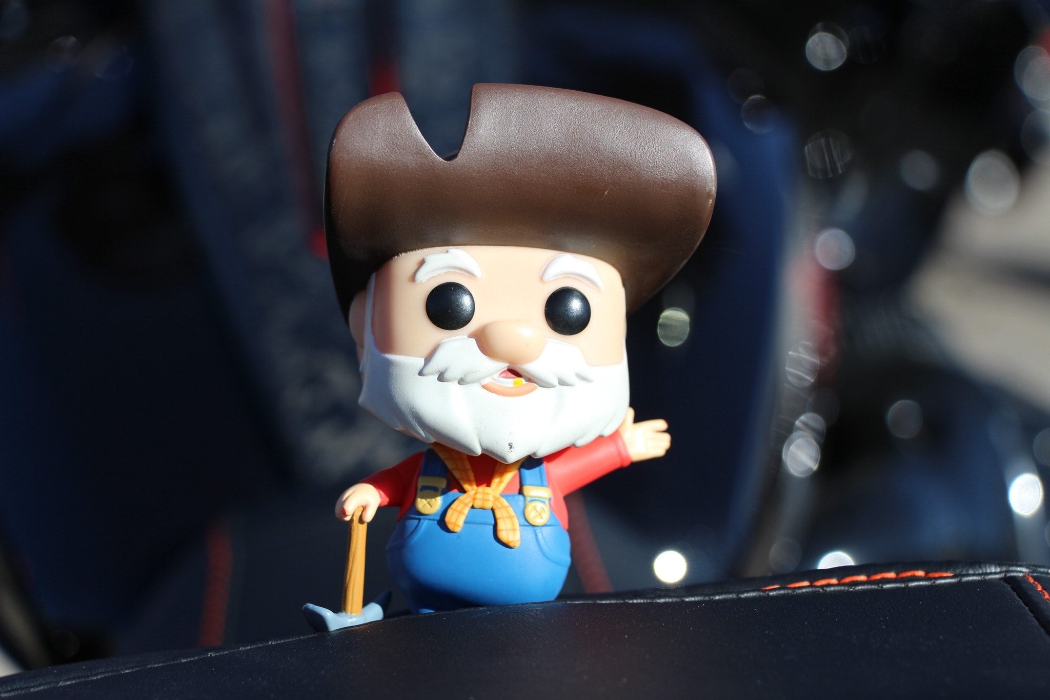 Funko Pop cowboy figurine perched on a motorcycle seat at a chapter ride stop