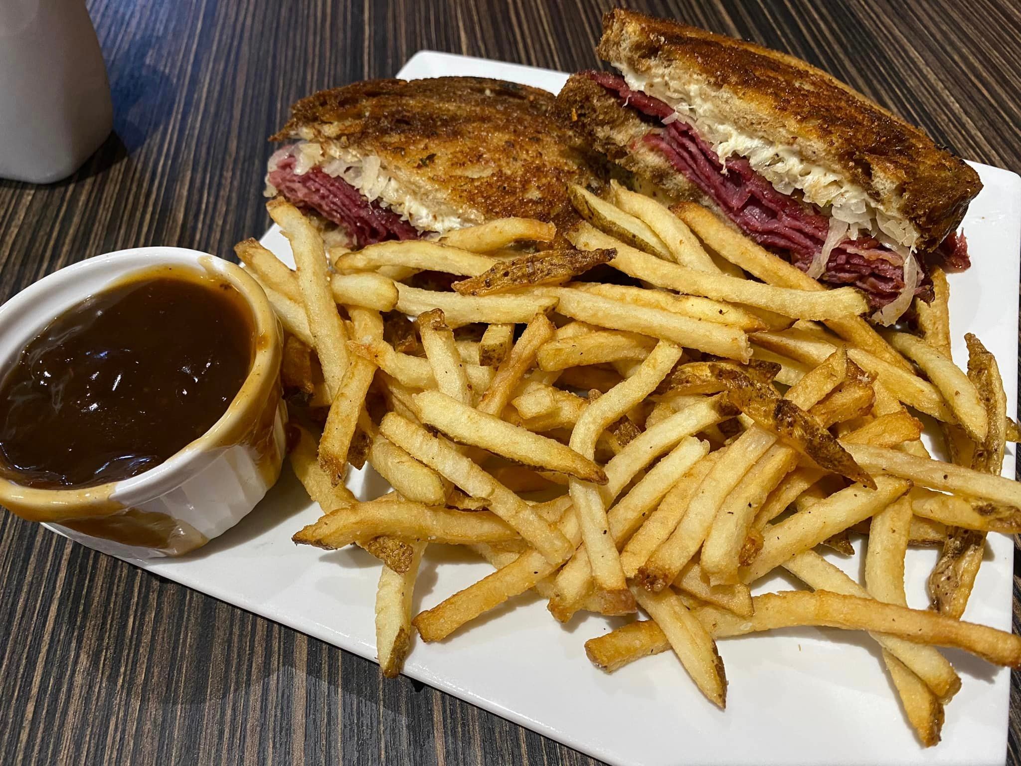 Reuben sandwich with thick-cut fries and a side of gravy at a chapter ride stop