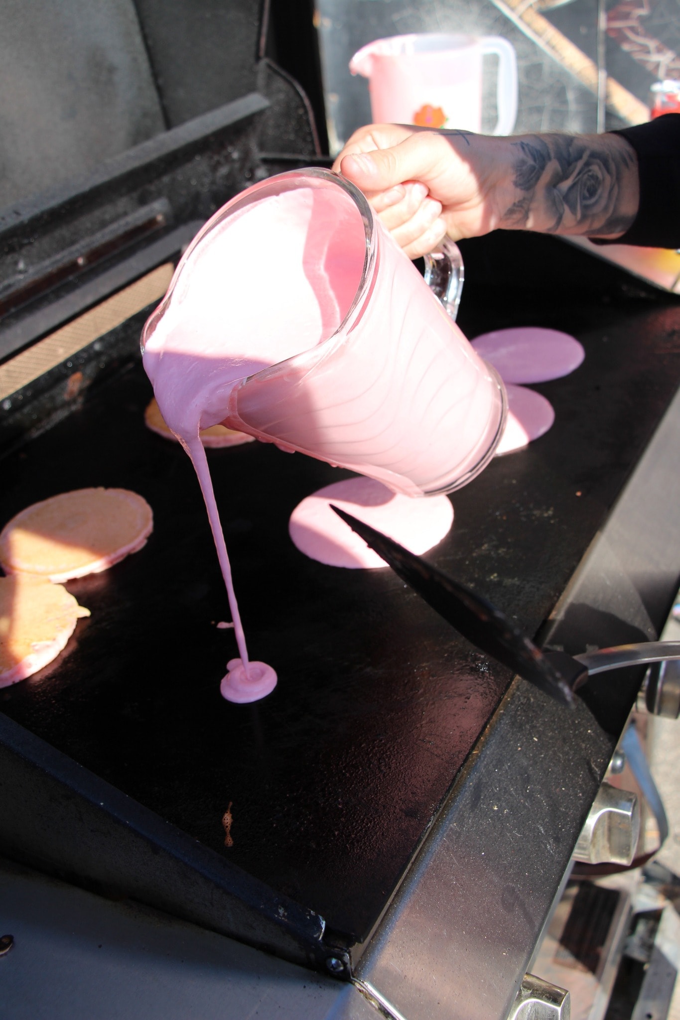 Pink pancake batter being poured onto a griddle at the 2024 Breast Cancer Awareness Ride breakfast
