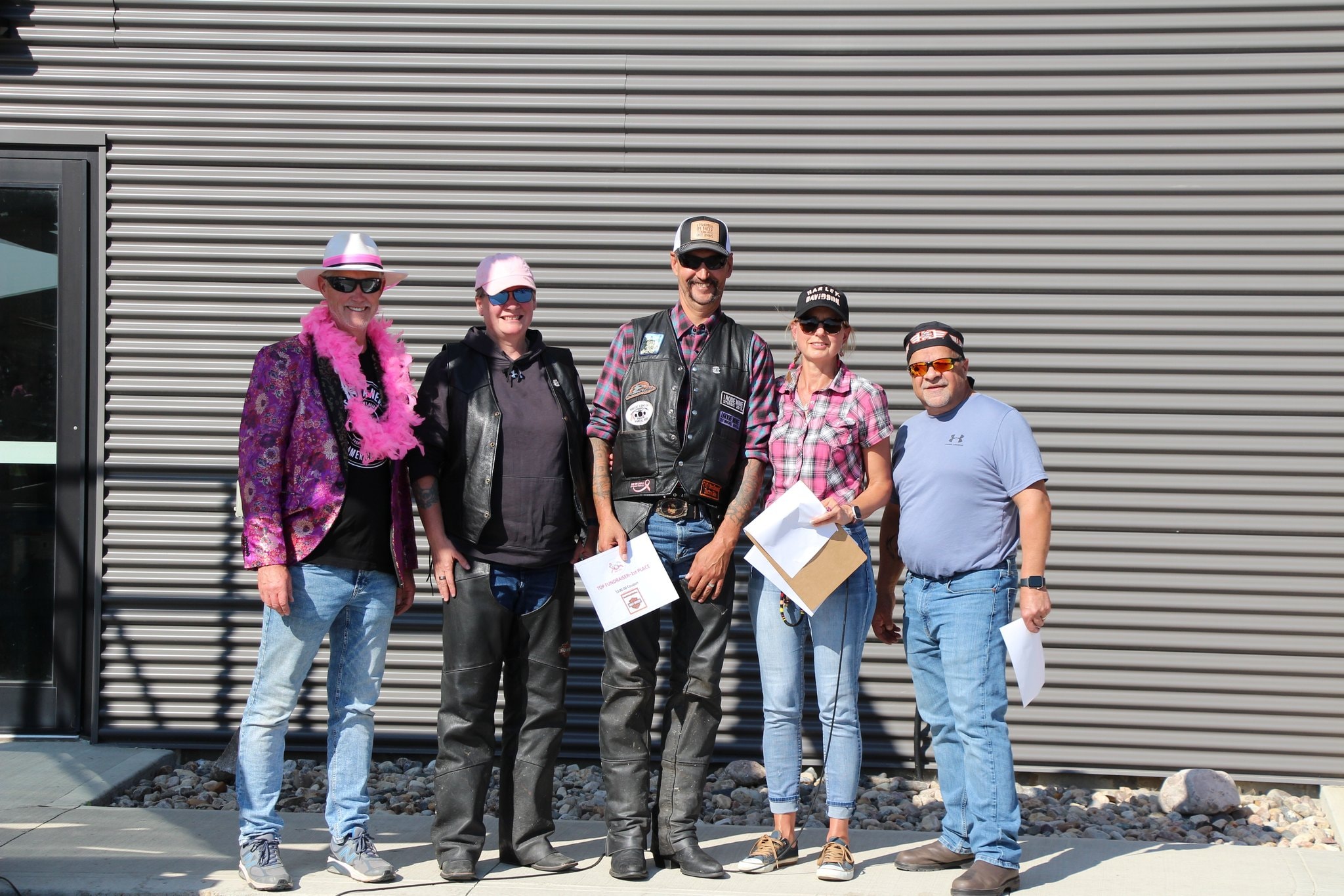 Five chapter members posing outside Prairie Harley-Davidson at the prize presentation after the charity ride
