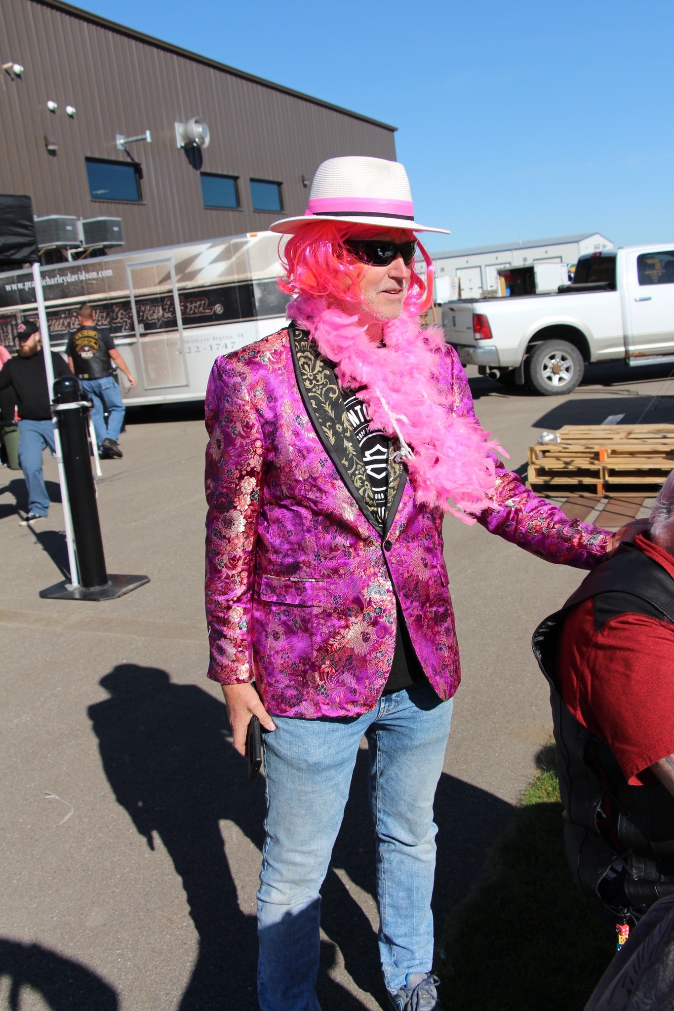 Member in a pink floral blazer, pink wig and feather boa at the 2024 Breast Cancer Awareness Ride