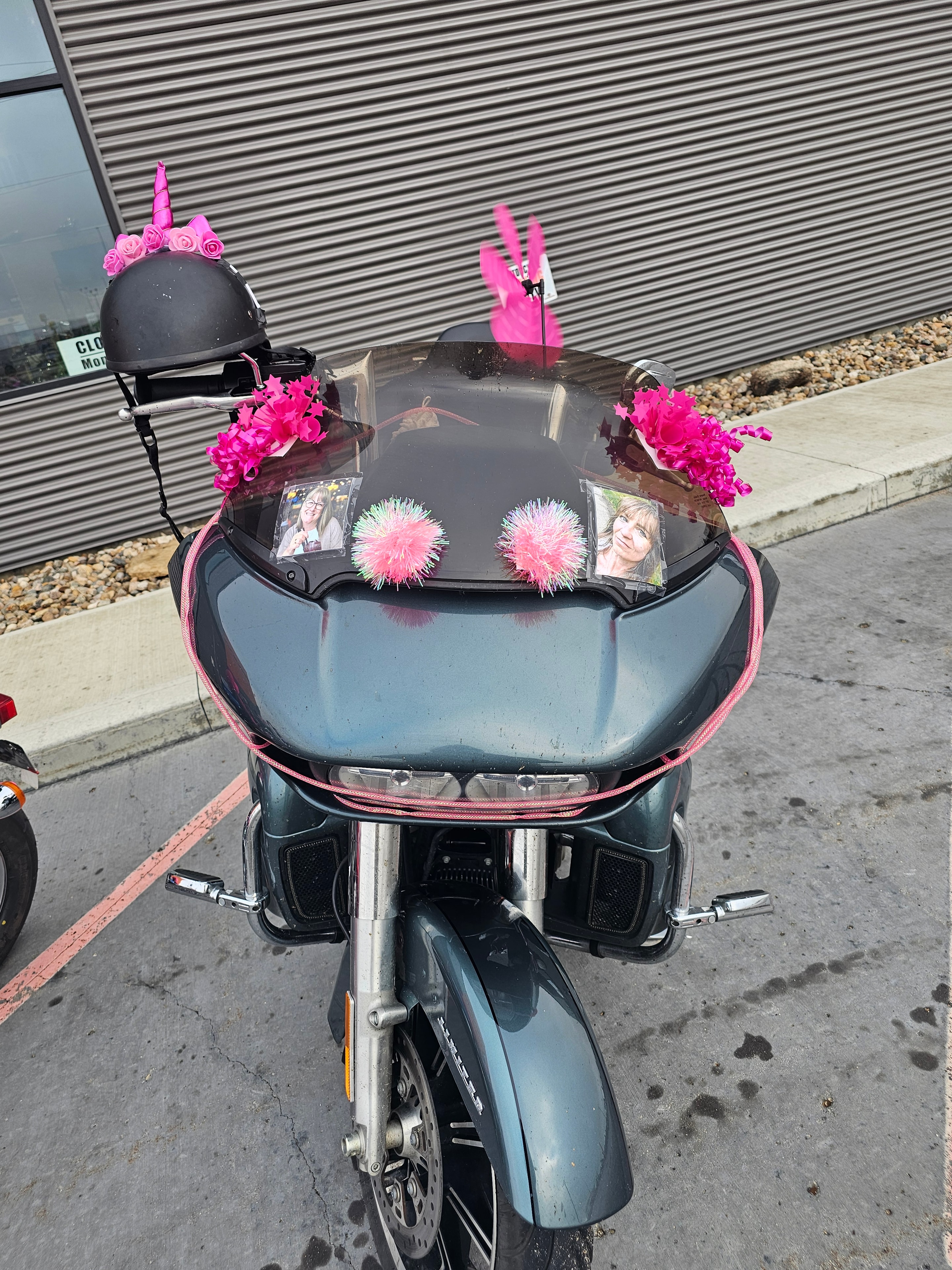 Same decorated Harley-Davidson from a slightly different angle at the 2025 Breast Cancer Awareness Ride, showing tribute photos tucked behind the windshield alongside the pink pompoms and flowers
